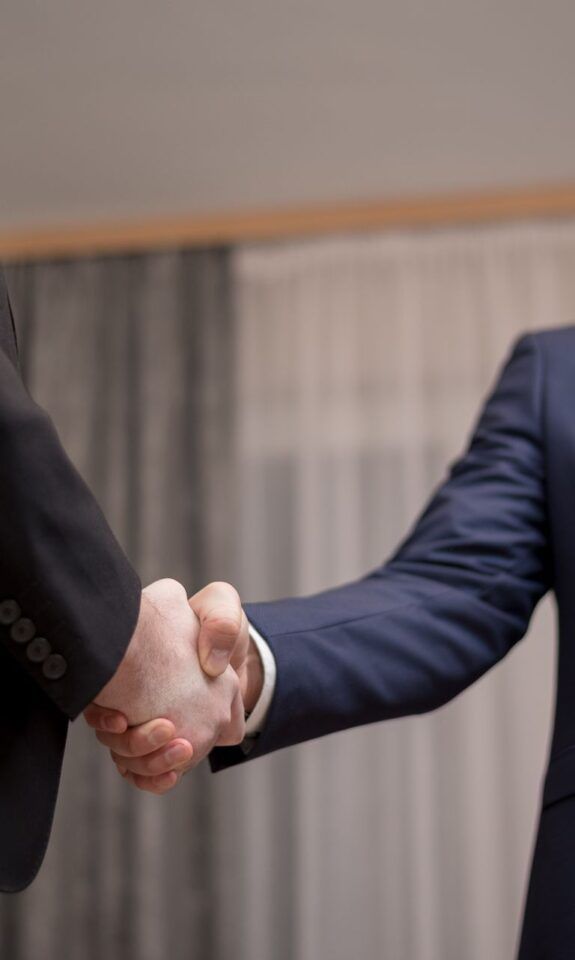 Two business owners shaking hands during a meeting