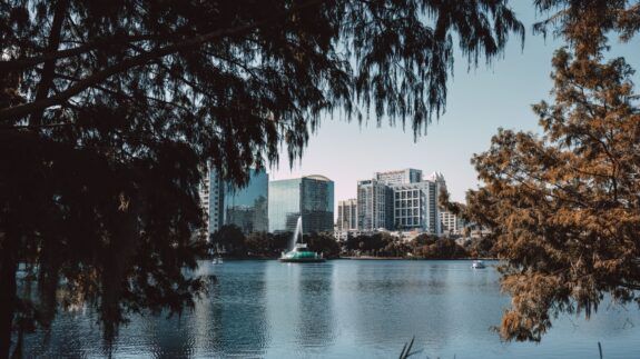 Downtown Orlando skyline framed by trees at Lake Eola