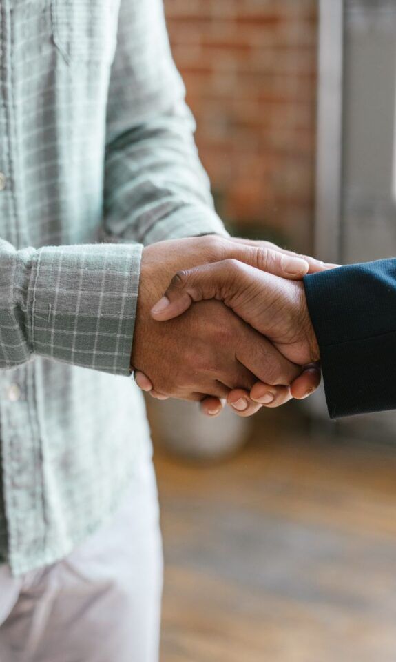Two business professionals shaking hands in an office