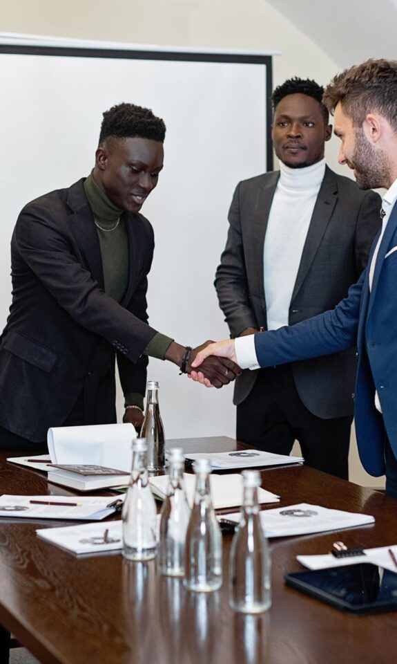 Professionals shaking hands in a modern office to signal agreement