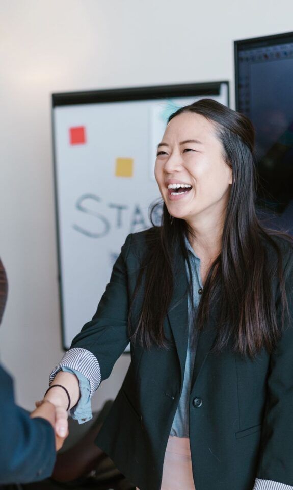 Two businesswomen shaking hands in an office