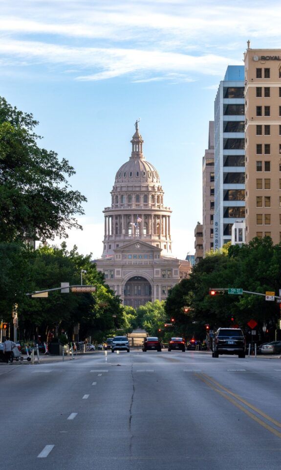 Texas State Capitol in Austin with surrounding skyscrapers