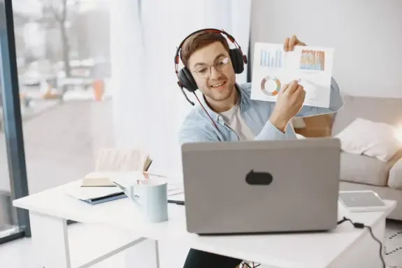 Founder on a video call holding up printed revenue charts
