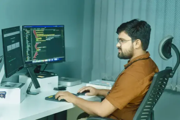 Software founder working at a desk with two monitors