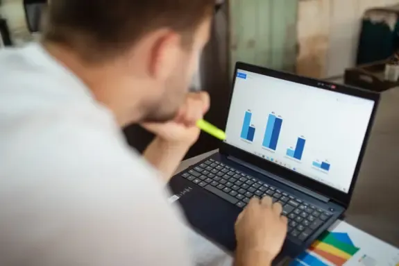 Founder studying a revenue bar chart on a laptop screen