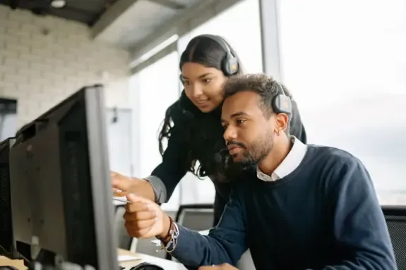 Hosting support engineers with headsets reviewing a customer ticket on screen